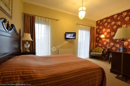 a bedroom with a bed and a couch and a desk at Arkadia Gościniec-klima,parking,ogród in Opole