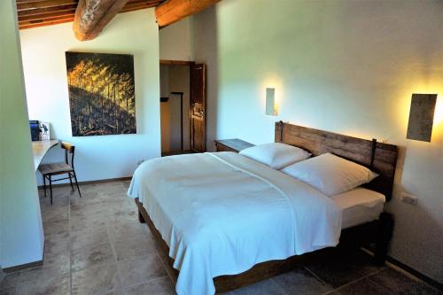 a bedroom with a large white bed and a desk at Casatorta in Vicchio