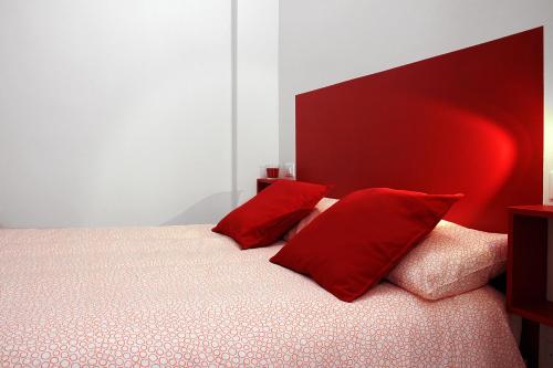 um quarto com uma cama com almofadas vermelhas em La Casa Di Eva em Bolonha