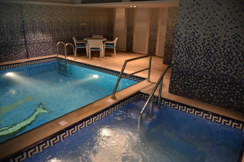 una gran piscina con mesa y sillas en una habitación de hotel en Home Inn Hotel Suites en Al Khobar