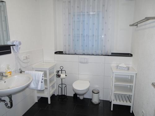 ein weißes Bad mit einem WC und einem Waschbecken in der Unterkunft Hilda Apartments in Rust