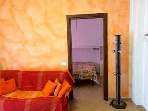 マリネッラ・ディ・サルザーナにあるLa Casetta di Marinellaのベッド1台、鏡、ドアが備わる客室です。
