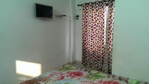 a room with a bed and a curtain with roses at Siva Inn in Guruvāyūr