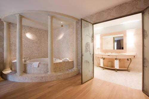 ein großes Bad mit einer Badewanne und einem Waschbecken in der Unterkunft Bad Bubendorf Design & Lifestyle Hotel in Bubendorf