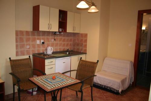 kuchnia ze stołem i 2 krzesłami oraz stołem i stołem w obiekcie Villa Patio w mieście Patince