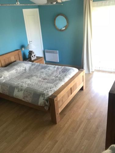 a bedroom with a bed and a blue wall at Relais de la Venise verte in Coulon