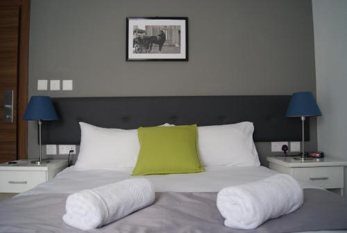 a bed with a green pillow on top of it at Buccaneers Boutique Guest House in St Paul's Bay
