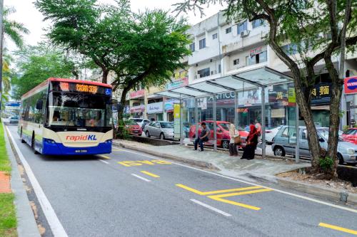 a bus is driving down a city street at LightHouse Hotel & ShortStay @ Damansara Uptown in Petaling Jaya