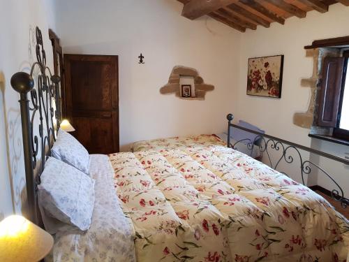 a bedroom with a bed with a comforter on it at Agriturismo La Guinza in Arcidosso