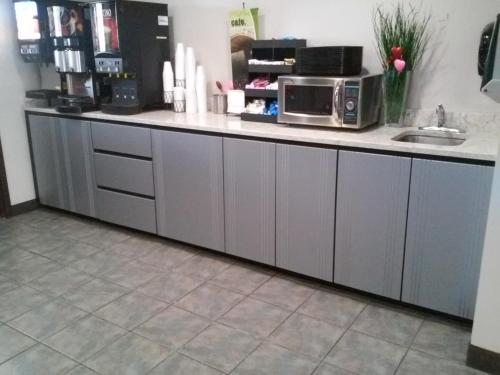 a kitchen with a counter with a microwave at Microtel Inn and Suites Manistee in Manistee