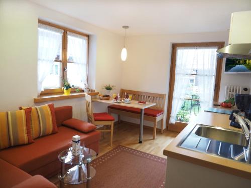 eine Küche und ein Wohnzimmer mit einem Sofa und einem Tisch in der Unterkunft Haus Antonius in Oberstdorf