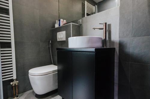 a bathroom with a white toilet and a sink at Amazing Penthouse old town in Sarajevo