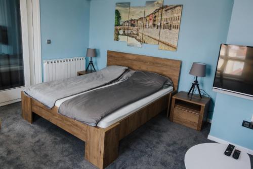 a bedroom with a bed and two tables and a television at Amazing Penthouse old town in Sarajevo