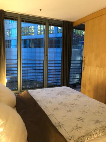 ein Schlafzimmer mit einem großen Bett und einem großen Fenster in der Unterkunft Suite im Sony Center am Potsdamer Platz in Berlin