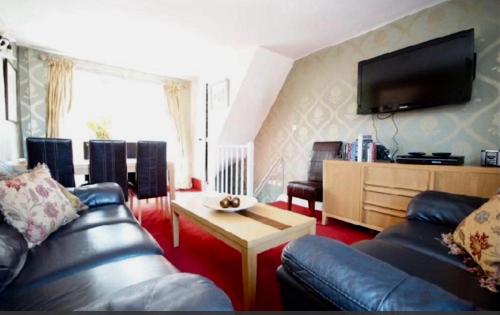 a living room with a couch and a tv at Castle View Cottage in Lincoln