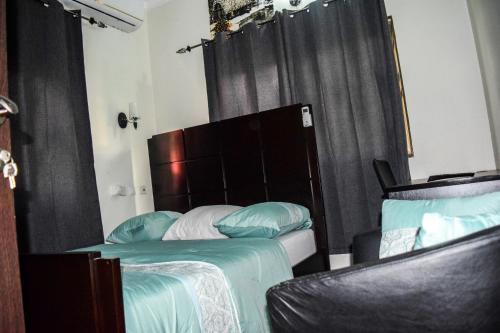 a bedroom with two beds with a headboard and two chairs at 3A's Guest House in Oko Sombo