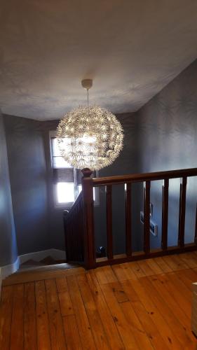 a chandelier hanging from a ceiling in a room at la maison du postier in Port-en-Bessin-Huppain