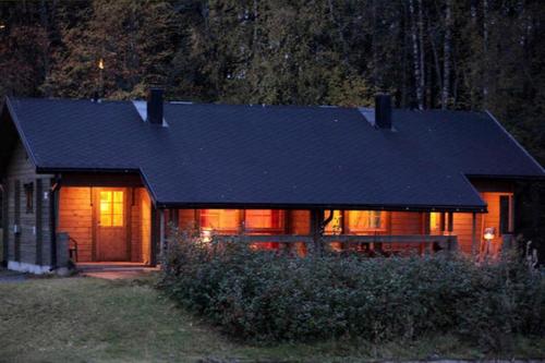 a house with a black roof and a house at Koivula Cottages in Jämsä