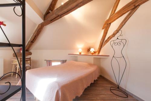 een slaapkamer met een bed op zolder bij Le Mariecalou in Meloisey