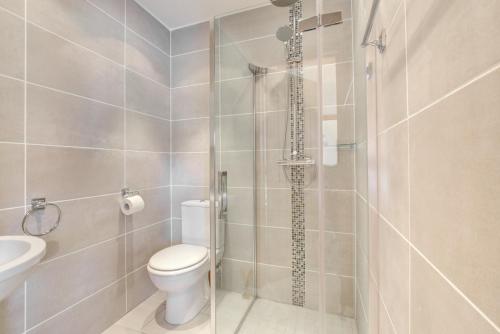 uma casa de banho com um chuveiro, um WC e um lavatório. em Y Golomen em Cardiff