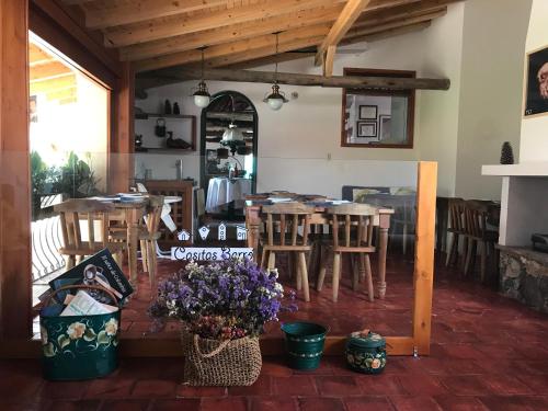 a dining room with tables and chairs and flowers at Hotel Casitas Barro Iza Boyaca in Iza