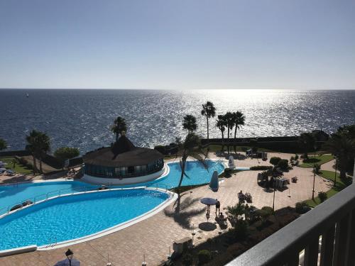 a swimming pool with the ocean in the background at Rocas del Mar in Costa Del Silencio