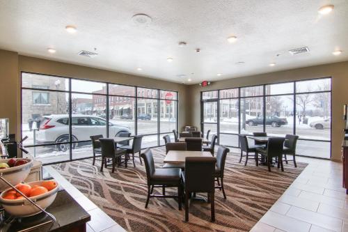 a restaurant with tables and chairs and windows at Cobblestone Inn & Suites - Menomonie/UW-Stout in Menomonie