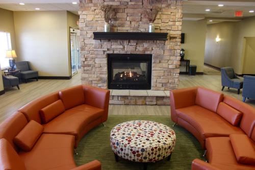 a waiting room with two chairs and a fireplace at MainStay Suites Fitchburg - Madison in Madison