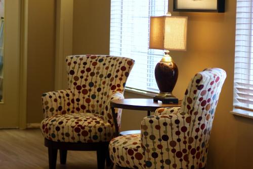 a room with two chairs and a table and a lamp at MainStay Suites Fitchburg - Madison in Madison