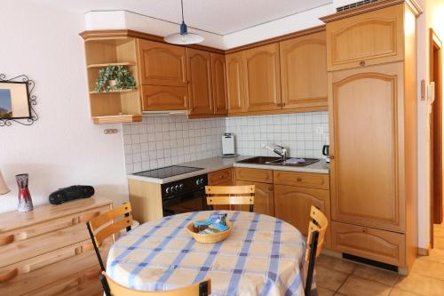 a kitchen with wooden cabinets and a table and chairs at Adlerhorst in Leukerbad