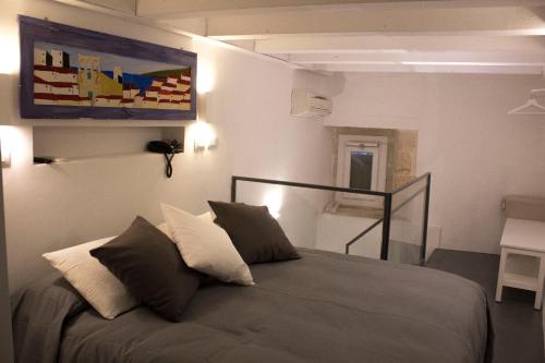 a bedroom with a bed and a painting on the wall at Aretusa Vacanze B&B in Siracusa