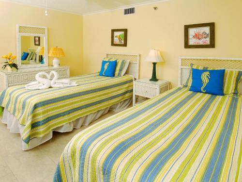twee bedden in een kamer met blauw en geel bij Phoenix East Unit 607 in Orange Beach
