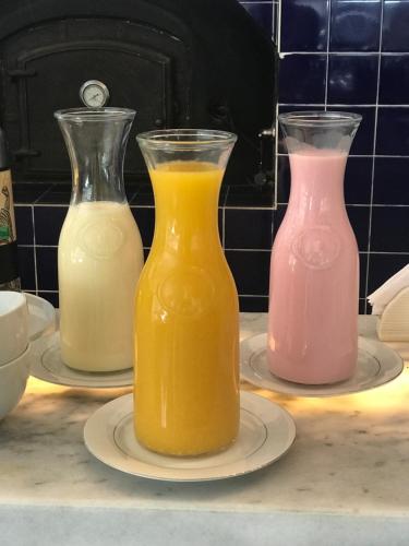 three glass vases filled with orange and pink juice at Casa Daupi in Mar del Plata