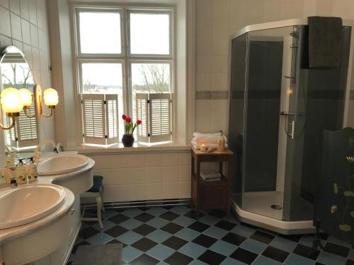 カールスタードにあるBerg Säteriのバスルーム(洗面台2台、シャワー、トイレ付)