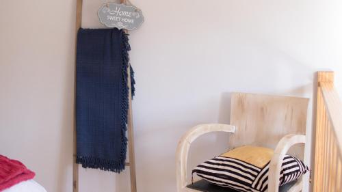 a wooden chair sitting next to a wall at Casa das Andorinhas in Ponte de Lima