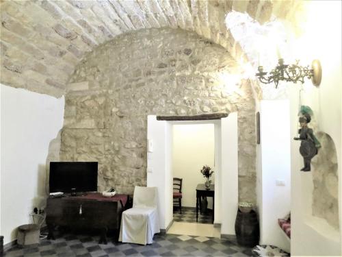 a room with a stone wall and a chandelier at La Casa Delle Fate in Siracusa