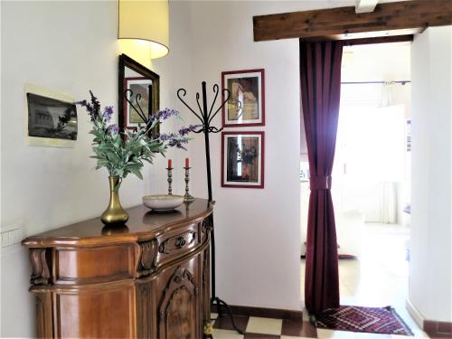 a room with a vase of flowers on a wooden cabinet at La Casa Delle Fate in Siracusa
