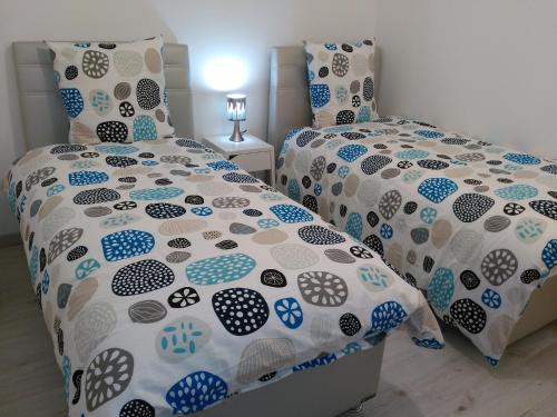 a bedroom with two beds with blue and white comforter at Bel et spacieux appartement de 84 m² avec parking très proche du Métro Garibaldi in Lyon