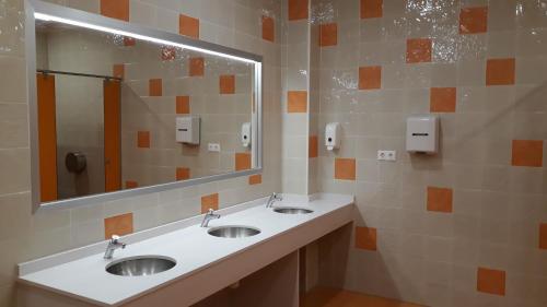 baño con 2 lavabos y espejo grande en Area de servicio El Rebollar, en Requena