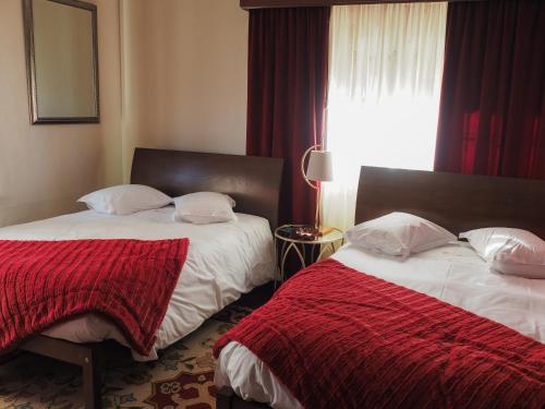 a bedroom with two beds and a window at Casa das Andorinhas in Ponte de Lima