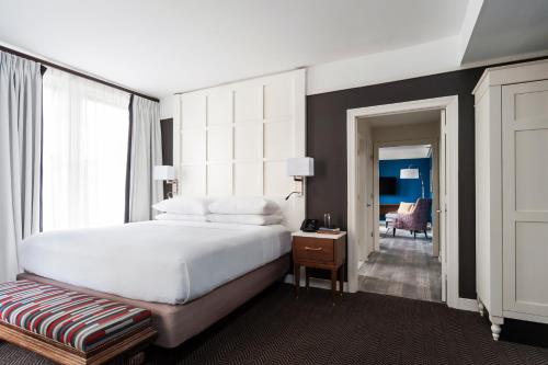 a bedroom with a large white bed and a chair at The Commonwealth in Richmond