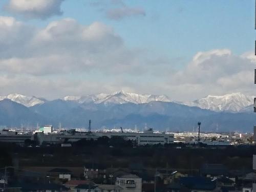 a city with snow capped mountains in the background at APA Hotel Gifu Hashima Ekimae in Hashima