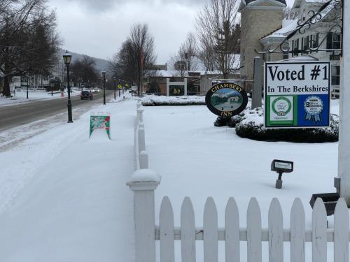 a white fence in a yard covered in snow at Chambery Inn in Lee
