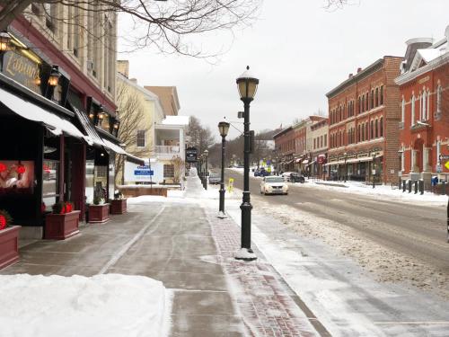 a snow covered street with two street lights on the sidewalk at Chambery Inn in Lee