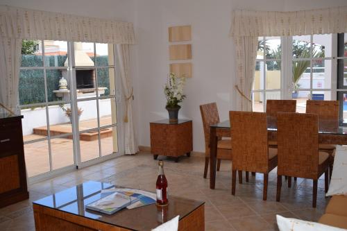 a living room with a dining room table and chairs at Villa Rochelle in Caleta De Fuste