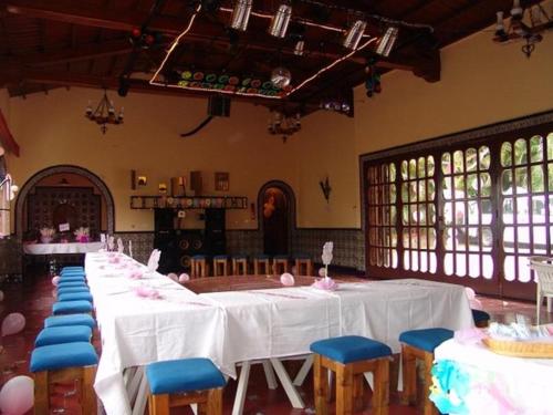 a room with a long table with blue chairs at Casa Madero Rooms in Cuernavaca