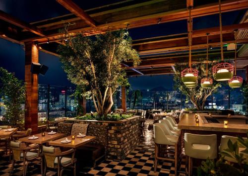 a restaurant with tables and chairs with a view at Dream Hollywood, by Hyatt in Los Angeles