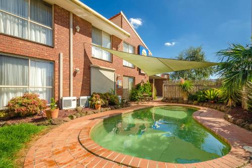 a swimming pool in the backyard of a house at Werribee Motel and Apartments in Werribee
