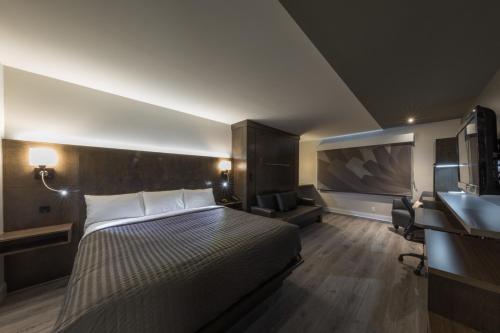 a hotel room with a bed and a sink at Hôtel & Suites Normandin Lévis in Lévis