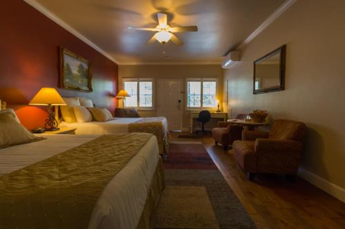 a hotel room with two beds and a table and chairs at Grass Valley Courtyard Suites in Grass Valley